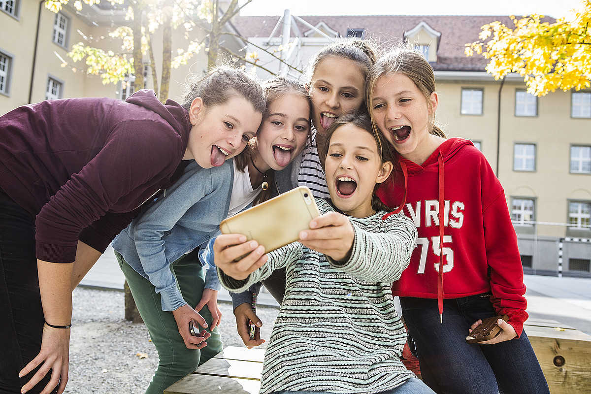 Fünf jugendliche Mädchen, welche ein Selfie aufnehmen.