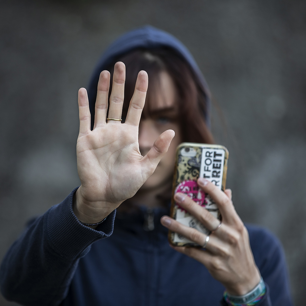 Eine aufhaltende Hand mit einem Ring am Mittelfinger.
