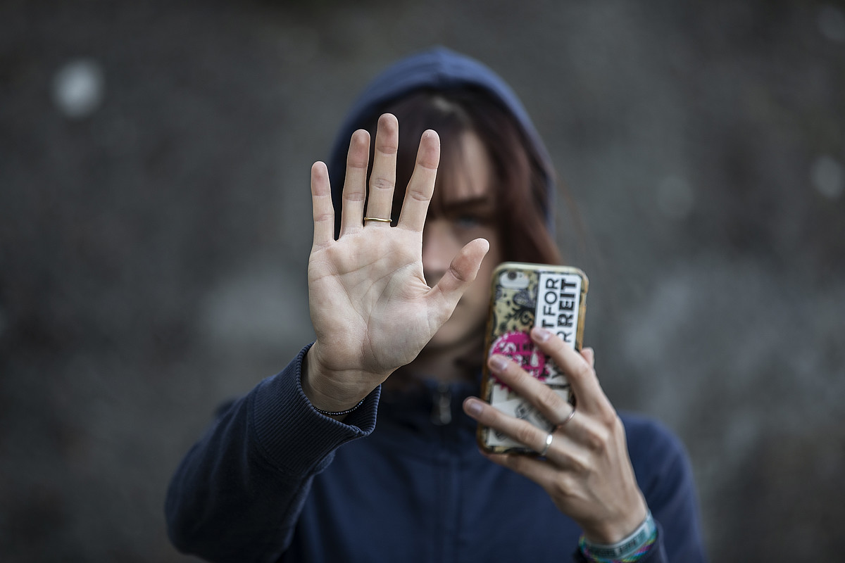 Eine aufhaltende Hand mit einem Ring am Mittelfinger.