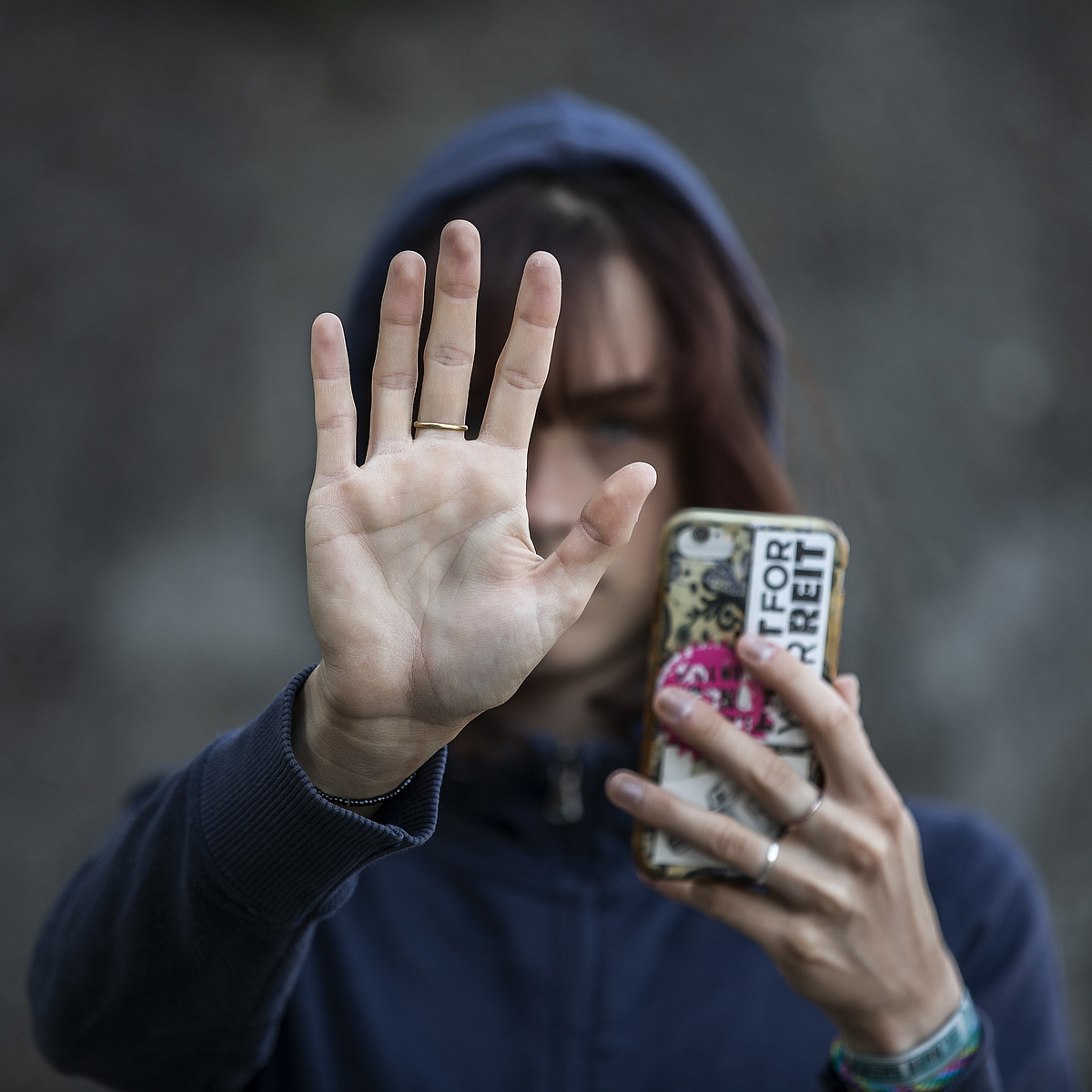 Eine aufhaltende Hand mit einem Ring am Mittelfinger.