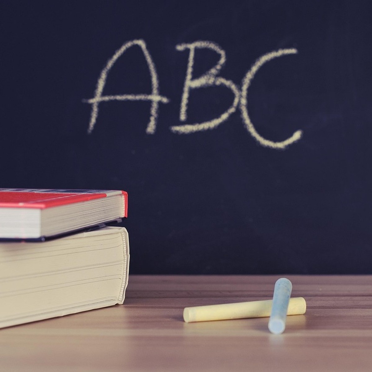 Wandtafel mit den Buchstaben A, B und C, Bücher und Kreide