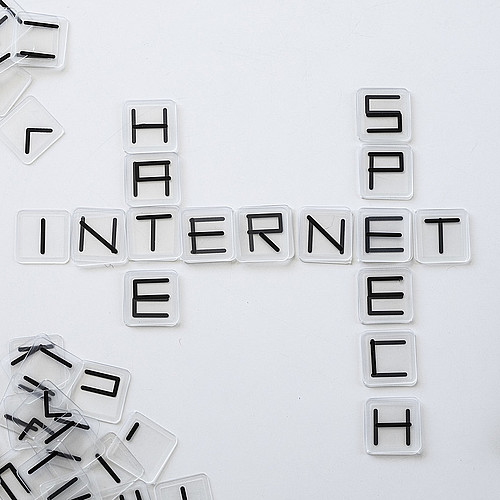 Auf dem Tisch stehen die Wörter "hate", "Internet" und "Speech".