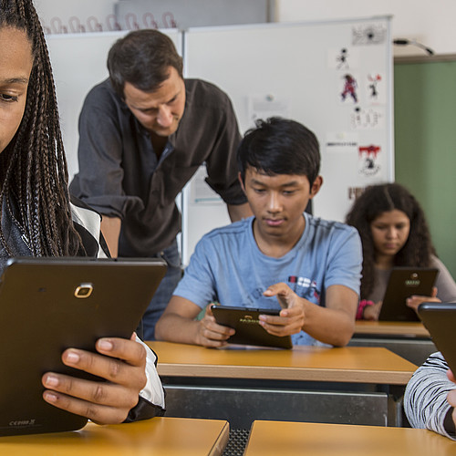 Schüler und Schülerinnen benützen das Handy im Unterricht.