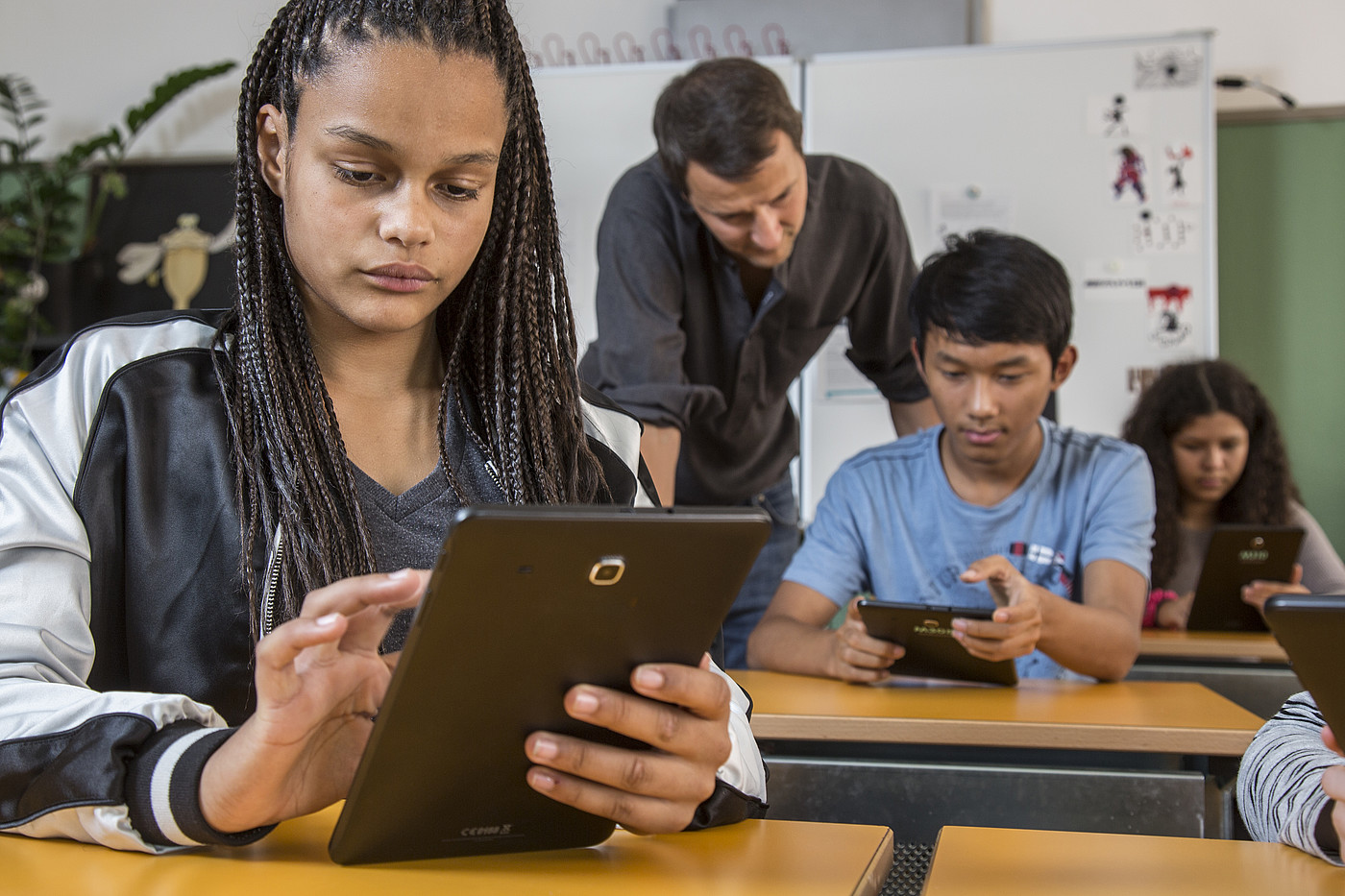Schüler und Schülerinnen benützen das Handy im Unterricht.
